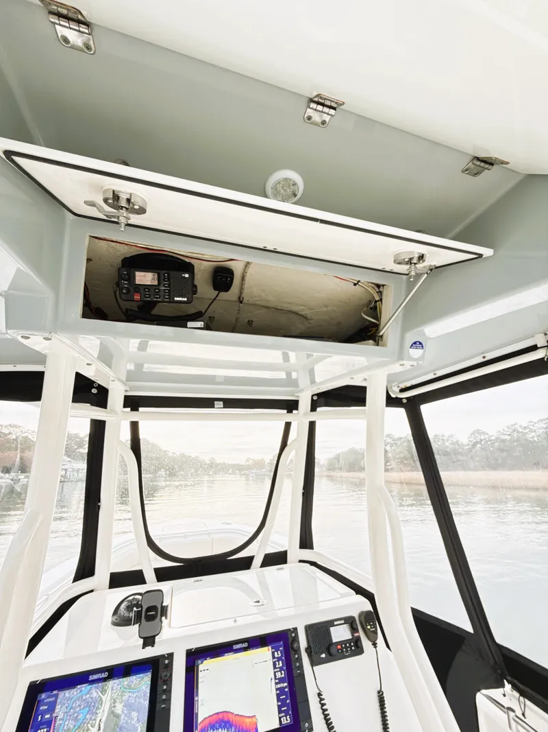 Slide: The Image of 2016 Cobia 296 Center Console boat interior with navigation equipment and storage compartment. - 15