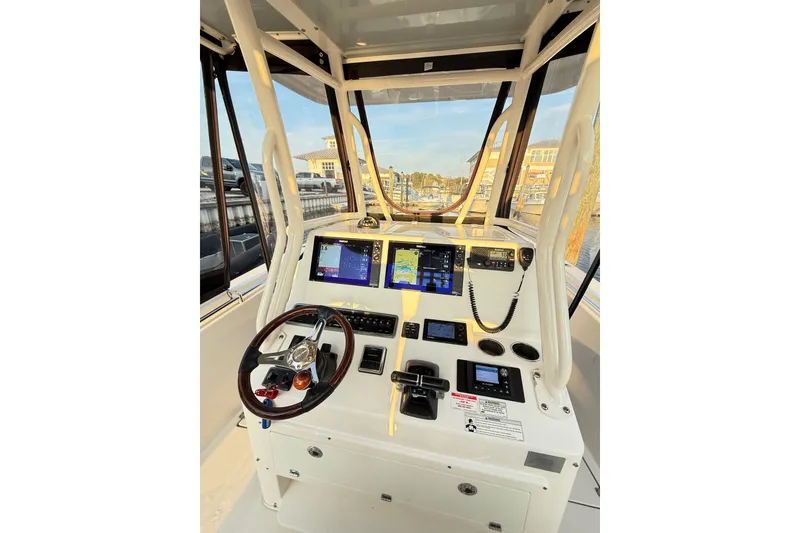 Slide: The Image of 2016 Cobia 296 Center Console boat dashboard with navigation screens and steering wheel. - 7