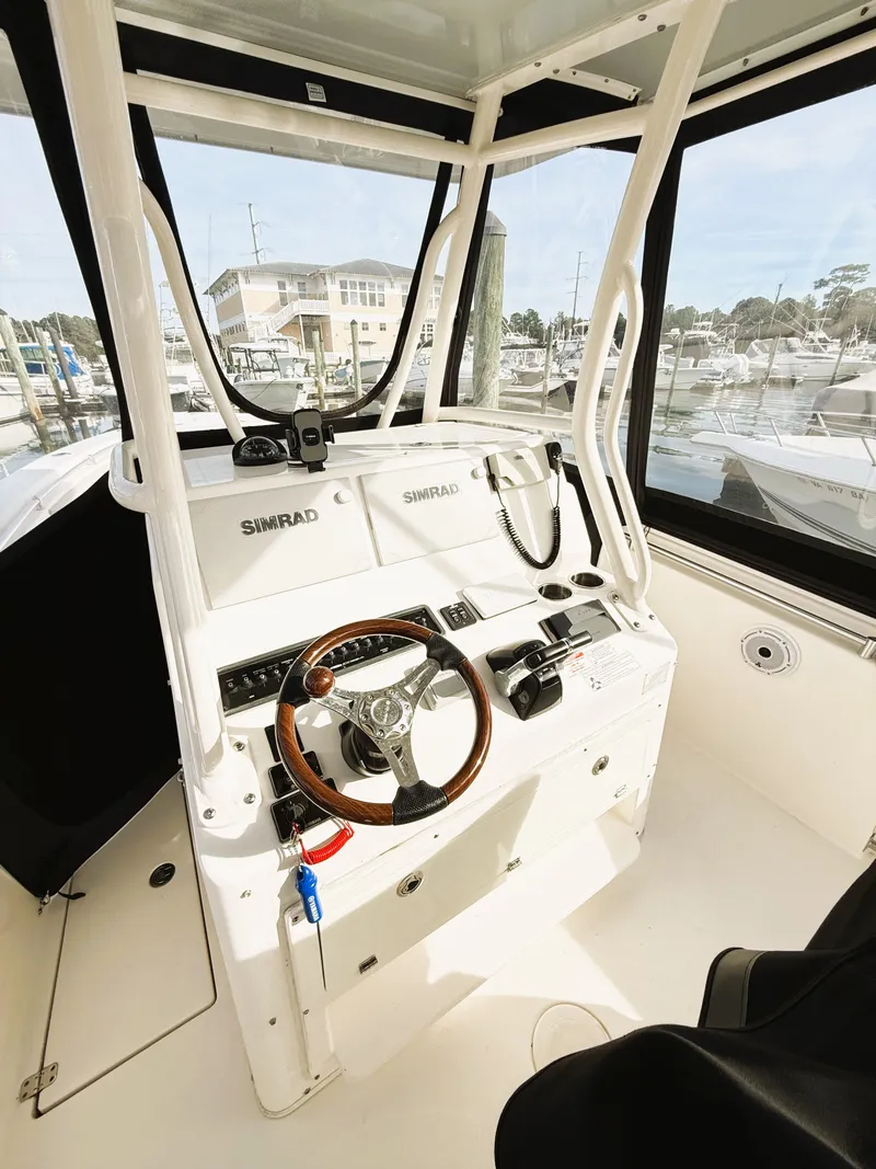 Slide: The Image of 2016 Cobia 296 Center Console boat interior with steering wheel and navigation equipment. - 22