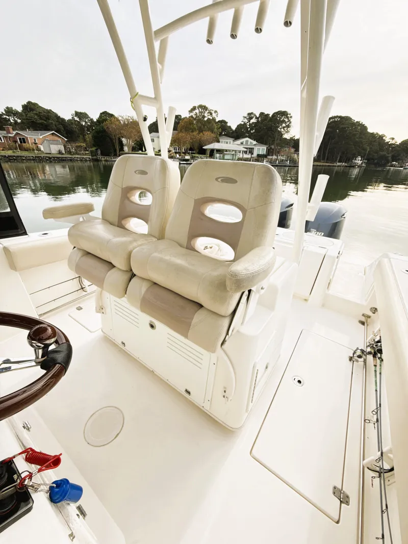 Slide: The Image of 2016 Cobia 296 Center Console boat with dual seats and scenic waterfront view. - 18