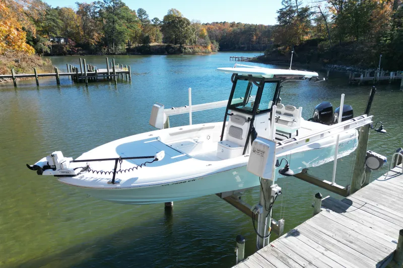 The Image of 2023 Caymas 281 HB boat docked on a serene lake with autumn foliage. - 1