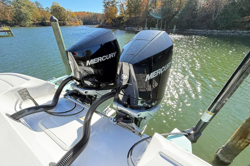 Slide: The Image of 2023 Caymas 281 HB boat with dual Mercury outboard engines on a sunny lake. - 11