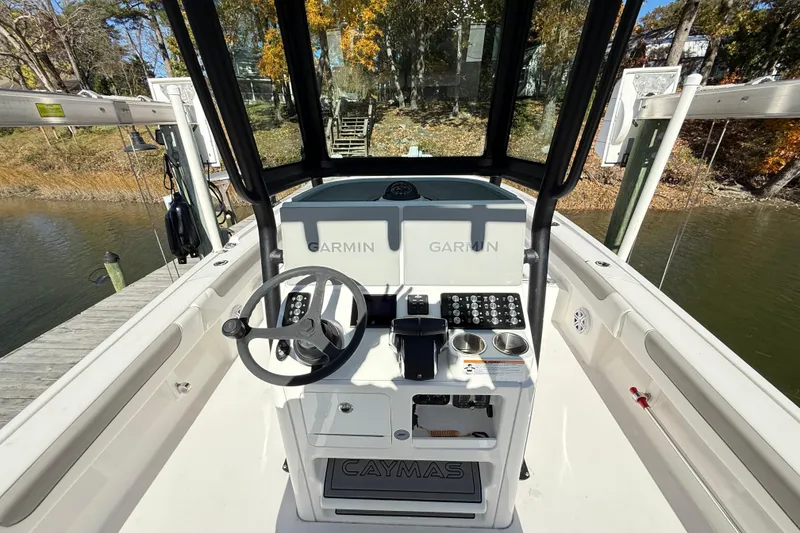 Slide: The Image of 2023 Caymas 281 HB boat helm with Garmin electronics, docked by a scenic waterway. - 38
