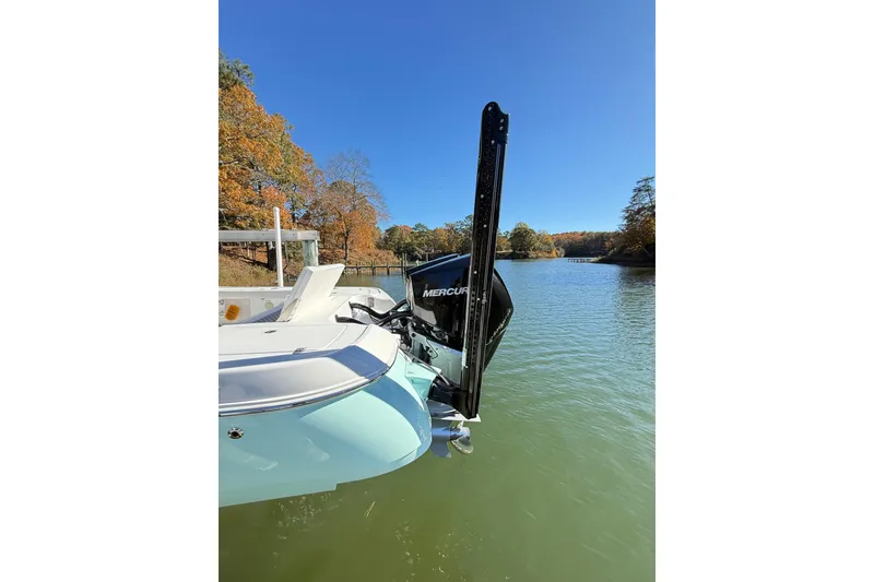 Slide: The Image of 2023 Caymas 281 HB boat on a serene lake with autumn foliage. - 10