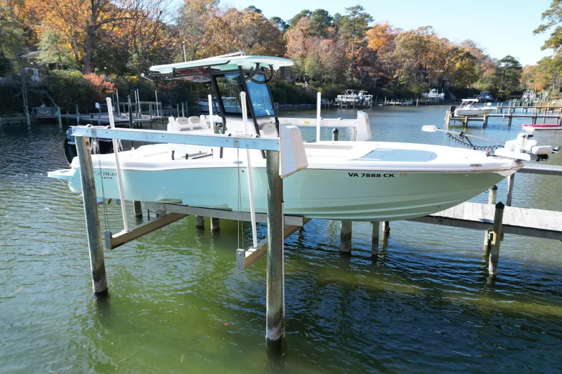 Slide: The Image of 2023 Caymas 281 HB boat on lift, docked in scenic autumn marina. - 2