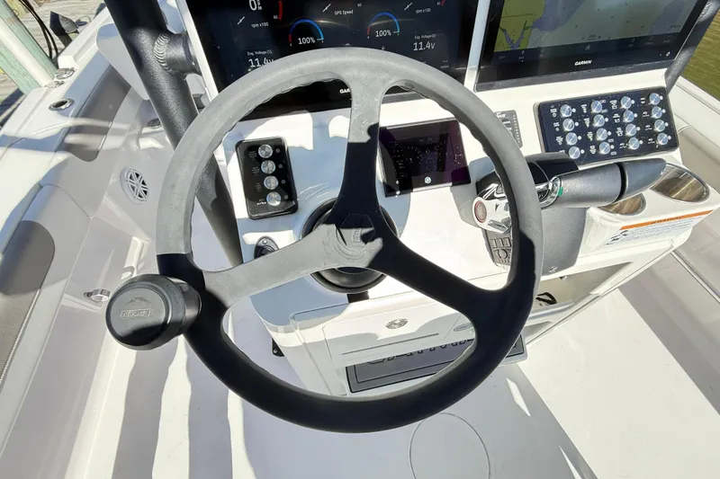 Slide: The Image of Steering wheel and dashboard of 2023 Caymas 281 HB boat, featuring modern controls. - 36
