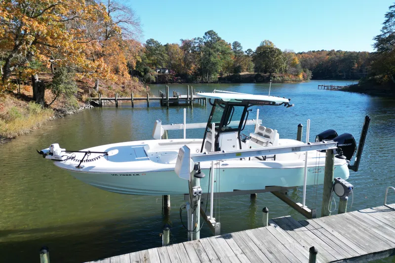 Slide: The Image of 2023 Caymas 281 HB boat docked on a serene lake with autumn foliage. - 4