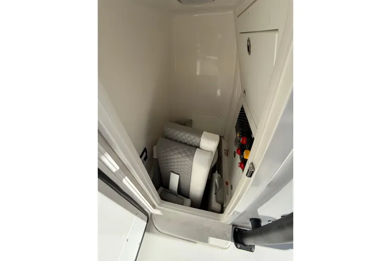 Slide: The Image of 2023 Caymas 281 HB interior storage with cushioned seating and control panel. - 59
