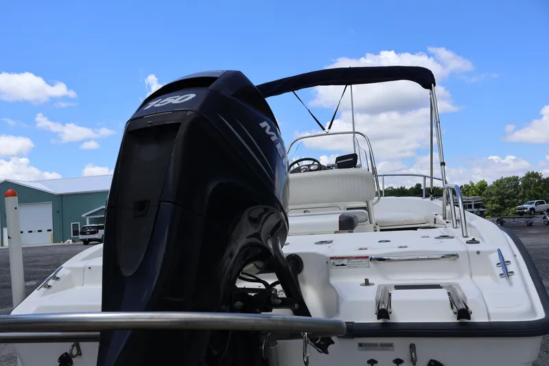 Slide: The Image of 2007 Boston Whaler 180 Dauntless boat with outboard motor, parked outdoors under blue sky. - 15