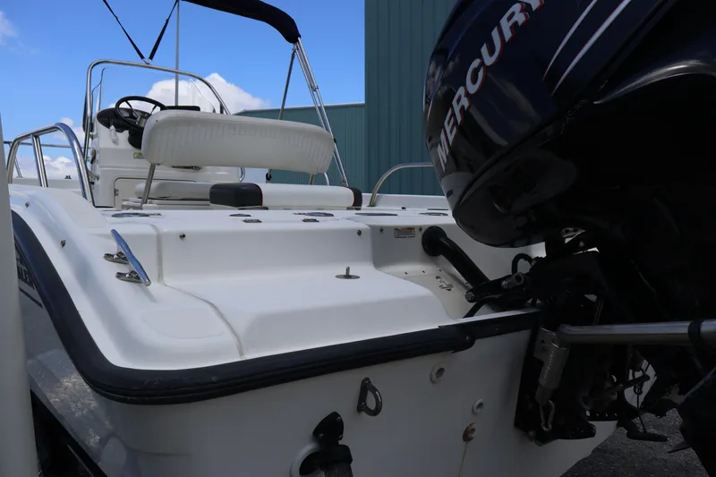 Slide: The Image of 2007 Boston Whaler 180 Dauntless boat with Mercury outboard motor, docked outdoors. - 11