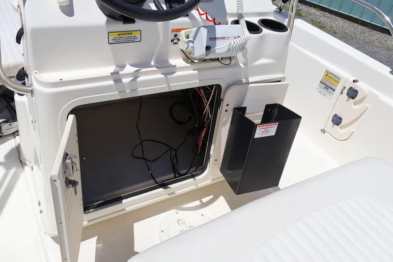 Slide: The Image of 2007 Boston Whaler 180 Dauntless boat console with open storage compartment and visible wiring. - 39