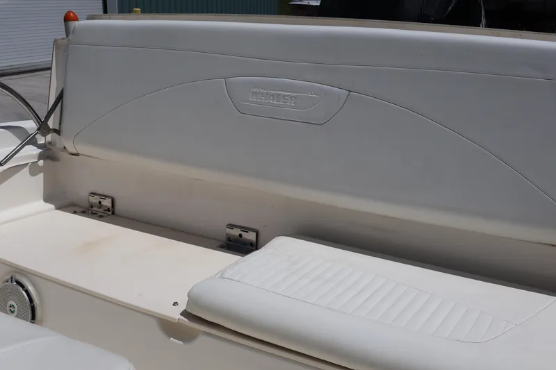 Slide: The Image of 2007 Boston Whaler 180 Dauntless boat seating area with white upholstery and logo detail. - 50
