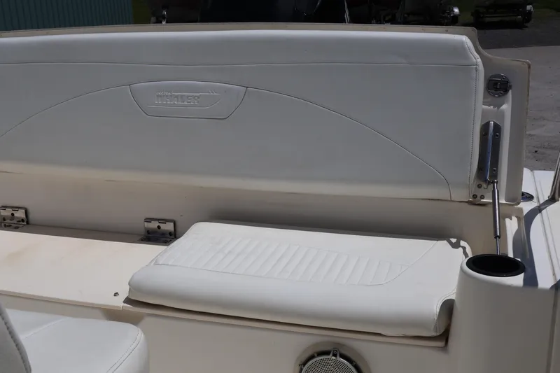 Slide: The Image of 2007 Boston Whaler 180 Dauntless boat seat with white upholstery and cup holder. - 49