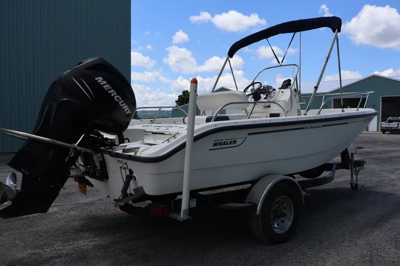 Slide: The Image of 2007 Boston Whaler 180 Dauntless boat with Mercury engine on trailer, parked outdoors. - 18