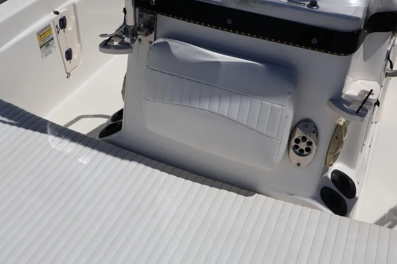 Slide: The Image of 2007 Boston Whaler 180 Dauntless boat interior with white cushioned seating and control panel. - 34