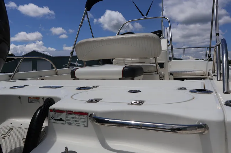 Slide: The Image of 2007 Boston Whaler 180 Dauntless boat interior with seating and storage, under a blue sky. - 19