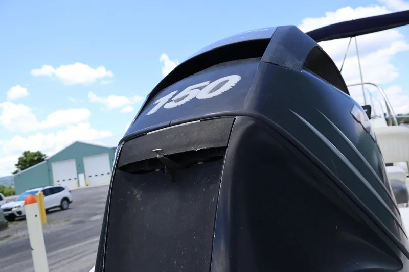 Slide: The Image of Outboard motor on a 2007 Boston Whaler 180 Dauntless, parked near a warehouse. - 16