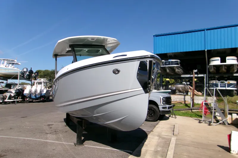 Slide: The Image of 2026 Monterey Elite 25 SD boat displayed outdoors at a marina under clear blue skies. - 20