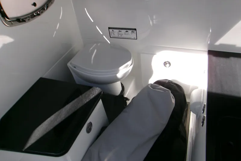 Slide: The Image of Interior of 2026 Monterey Elite 25 SD boat featuring compact bathroom amenities. - 13