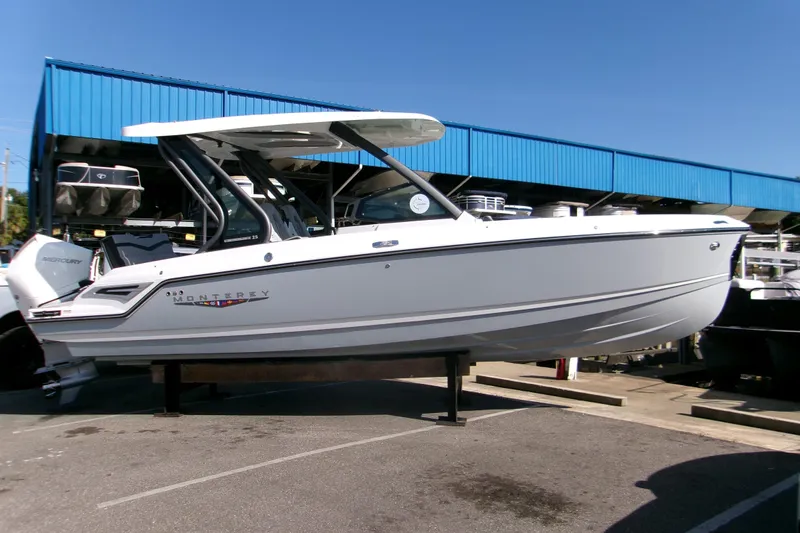 Slide: The Image of 2026 Monterey Elite 25 SD boat displayed outdoors under blue sky. - 19