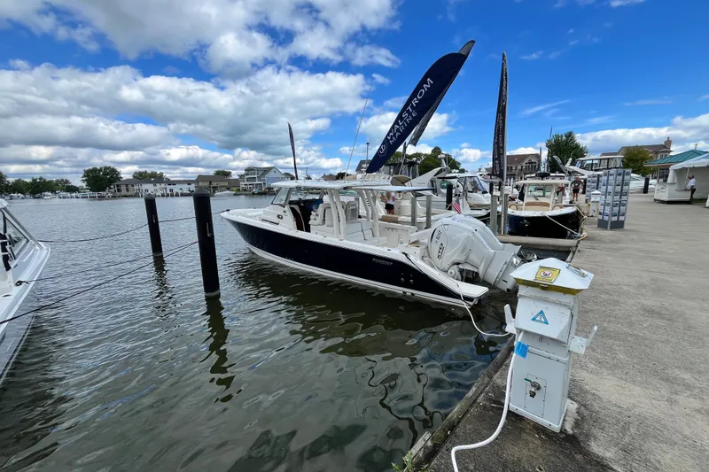 Slide: The Image of 2027 Pursuit S 358 Sport boat docked at marina under blue sky. - 3