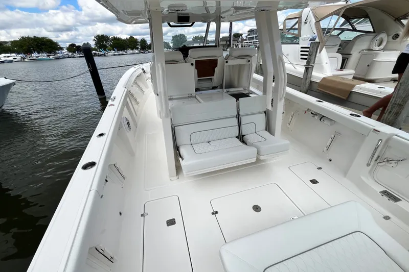 Slide: The Image of 2027 Pursuit S 358 Sport boat interior with seating and storage, docked at marina. - 4