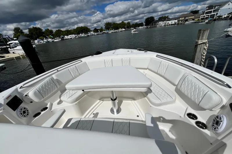 Slide: The Image of Luxurious 2027 Pursuit S 358 Sport boat interior with white seating and table, docked by the water. - 10