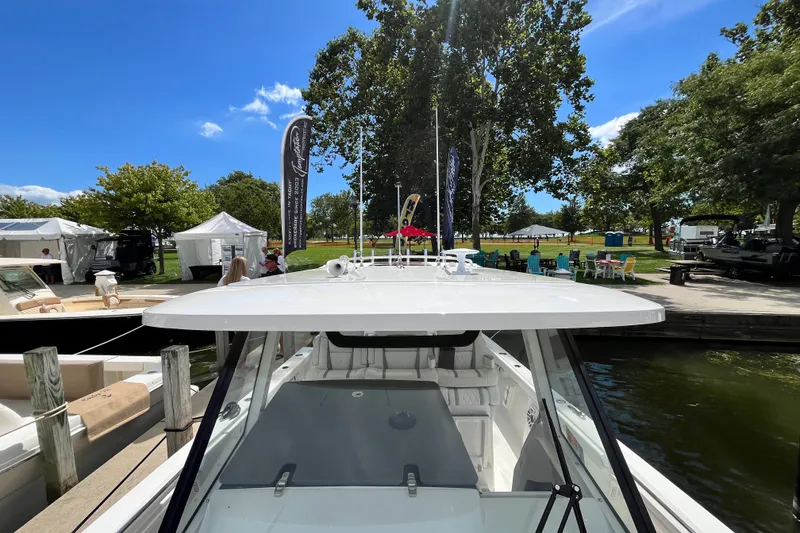 Slide: The Image of 2027 Pursuit S 358 Sport boat docked at a marina under a clear blue sky. - 7