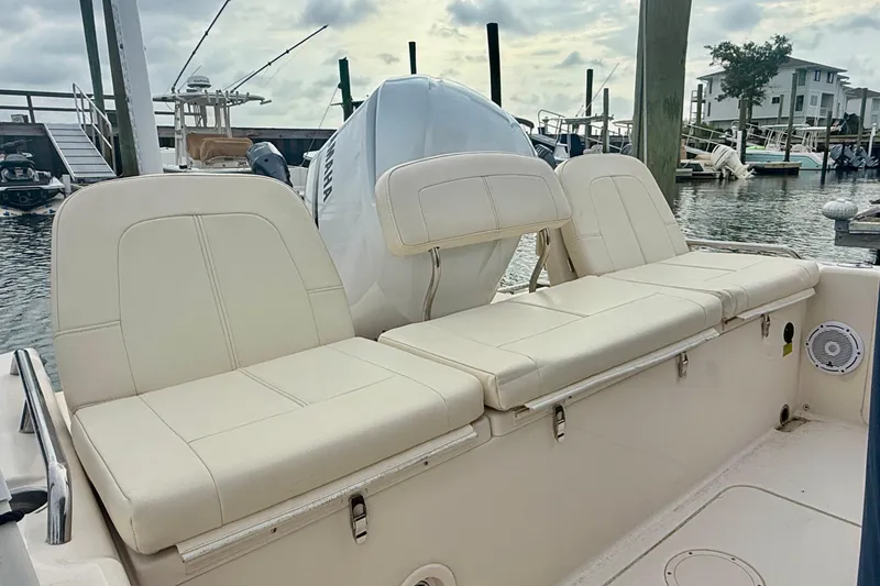 Slide: The Image of 2021 Grady-White 251 Coastal Explorer boat with cushioned seating at a marina. - 11