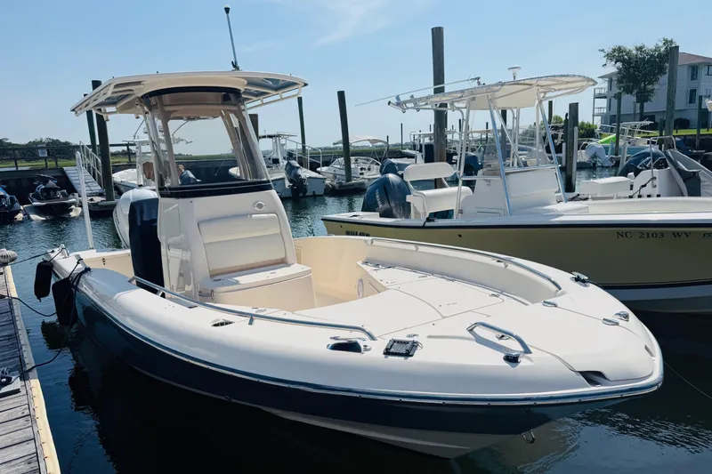 Slide: The Image of 2021 Grady-White 251 Coastal Explorer boat docked in a marina under clear skies. - 2