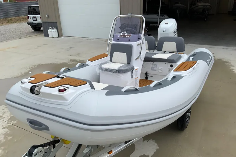 Slide: The Image of 2027 Gala V360 inflatable boat with modern design, parked on a trailer outside a garage. - 3