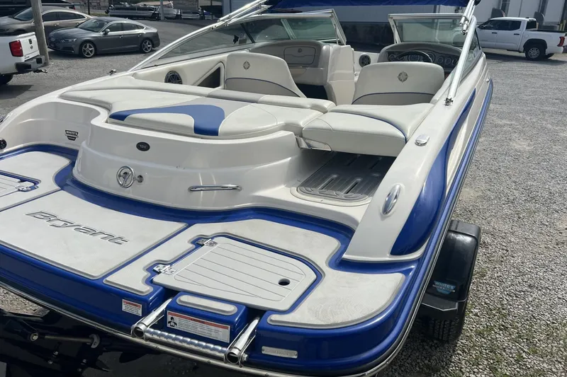 Slide: The Image of 2012 Bryant 196 boat with blue and white interior, parked on gravel. - 4