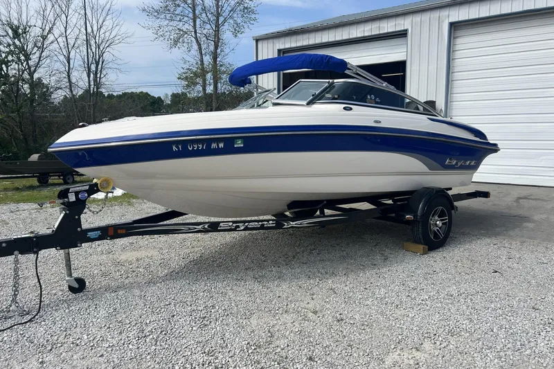 Slide: The Image of 2012 Bryant 196 boat on trailer, parked outside a garage. - 8