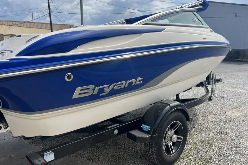 Slide: The Image of 2012 Bryant 196 boat in blue and white on a trailer, parked outdoors. - 3