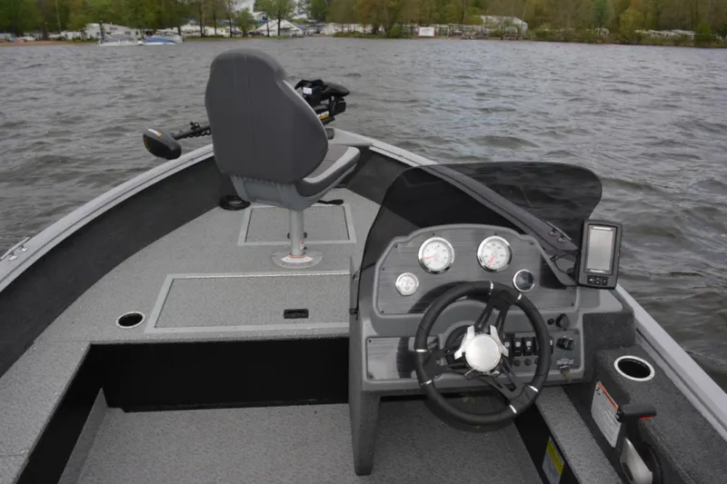 Slide: The Image of Manufacturer Provided Image: 2022 Starcraft Stealth 166 SC boat interior with steering console and seating on a lake. - 8
