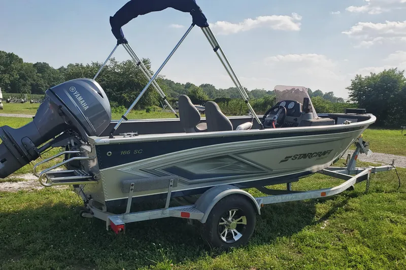 Slide: The Image of 2022 Starcraft Stealth 166 SC boat on trailer with Yamaha motor, parked on grass. - 2
