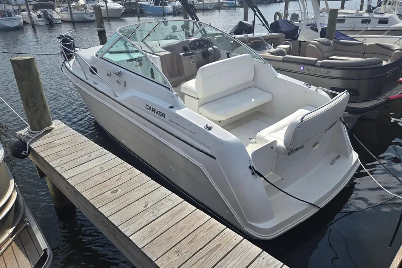 Slide: The Image of 1997 Carver 260 Mid Cabin Express boat docked at marina, featuring sleek design and spacious seating. - 8