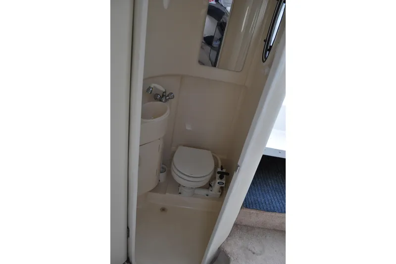 Slide: The Image of Compact bathroom in 1997 Carver 260 Mid Cabin Express boat, featuring toilet and sink. - 2