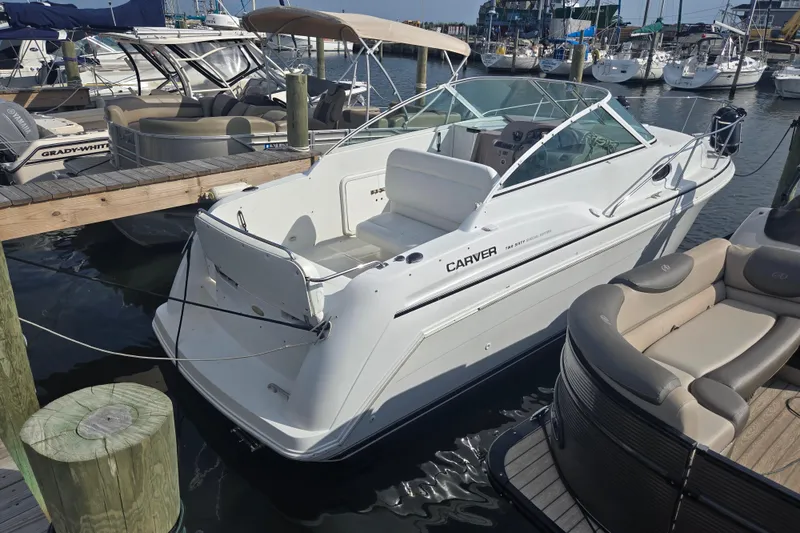The Image of 1997 Carver 260 Mid Cabin Express boat docked at marina, surrounded by other vessels. - 0