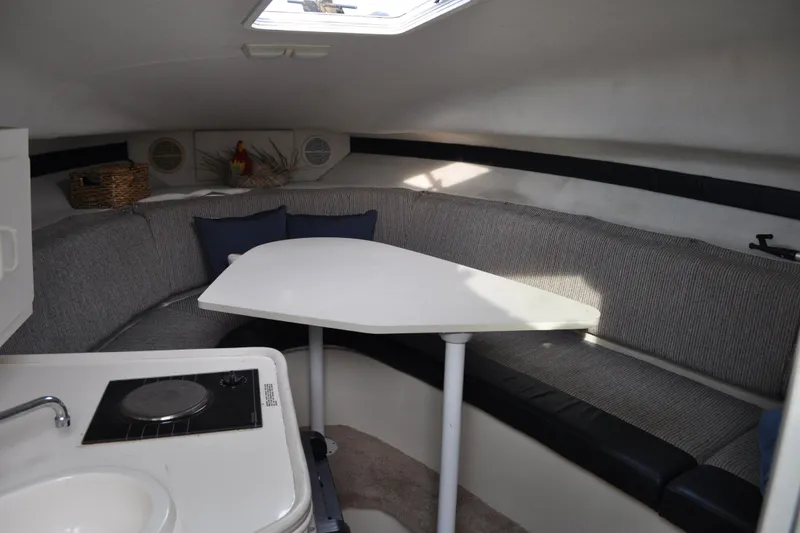 Slide: The Image of 1997 Carver 260 Mid Cabin Express interior with dining area and kitchenette. - 1