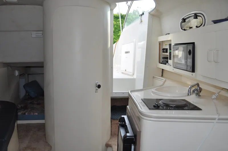Slide: The Image of Interior of 1997 Carver 260 Mid Cabin Express with kitchenette and cabin area. - 6