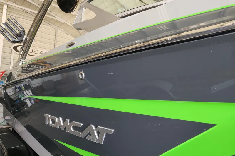 Slide: The Image of 2015 MB SPORTS F22 Tomcat boat with sleek green and black design in a showroom. - 7