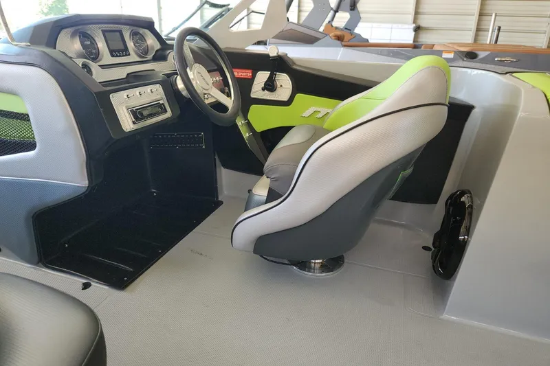 Slide: The Image of Interior of 2015 MB SPORTS F22 Tomcat boat with modern dashboard and green-accented seating. - 4