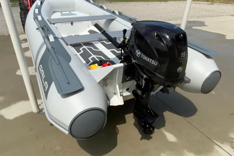 The Image of Inflatable boat Gala A330D 2027 with Tohatsu 15HP outboard motor on concrete surface. - 1