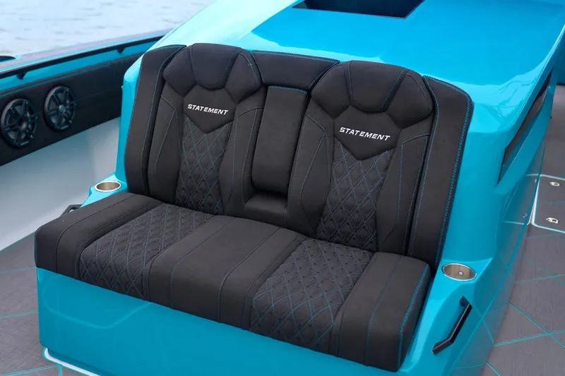 Slide: The Image of Manufacturer Provided Image: Luxurious seating on 2025 Statement 430 Tigress boat, featuring sleek black and blue design. - 7