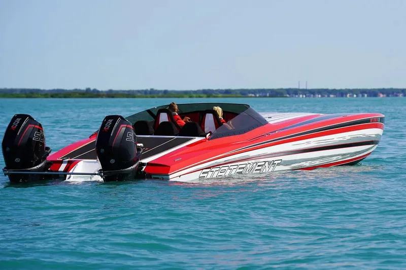 Slide: The Image of Manufacturer Provided Image: Red and white Statement 360 CAT speedboat on blue water, featuring dual outboard engines. - 1