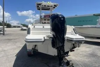 Slide: The Image of 2023 Trophy T24 CC boat with outboard motor in a sunny marina setting. - 6