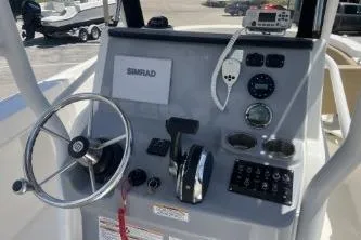 Slide: The Image of 2023 Trophy T24 CC boat dashboard with steering wheel, controls, and Simrad display. - 8