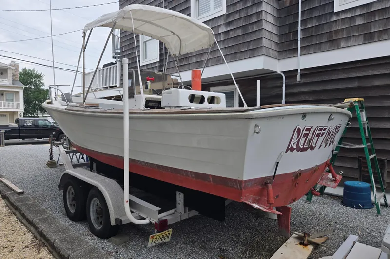 Slide: The Image of 1974 Chris-Craft 22 Tournament Fisherman boat on trailer, parked near a house. - 7