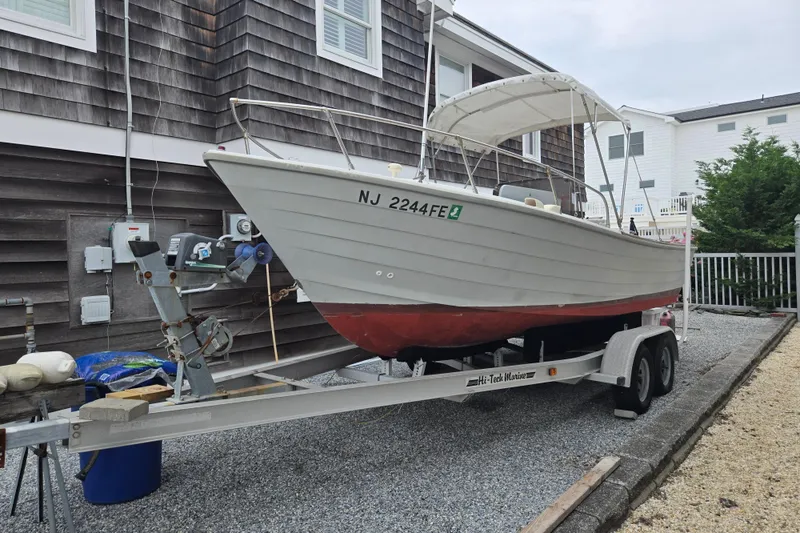 The Image of 1974 Chris-Craft 22 Tournament Fisherman boat on trailer, parked beside a house. - 0